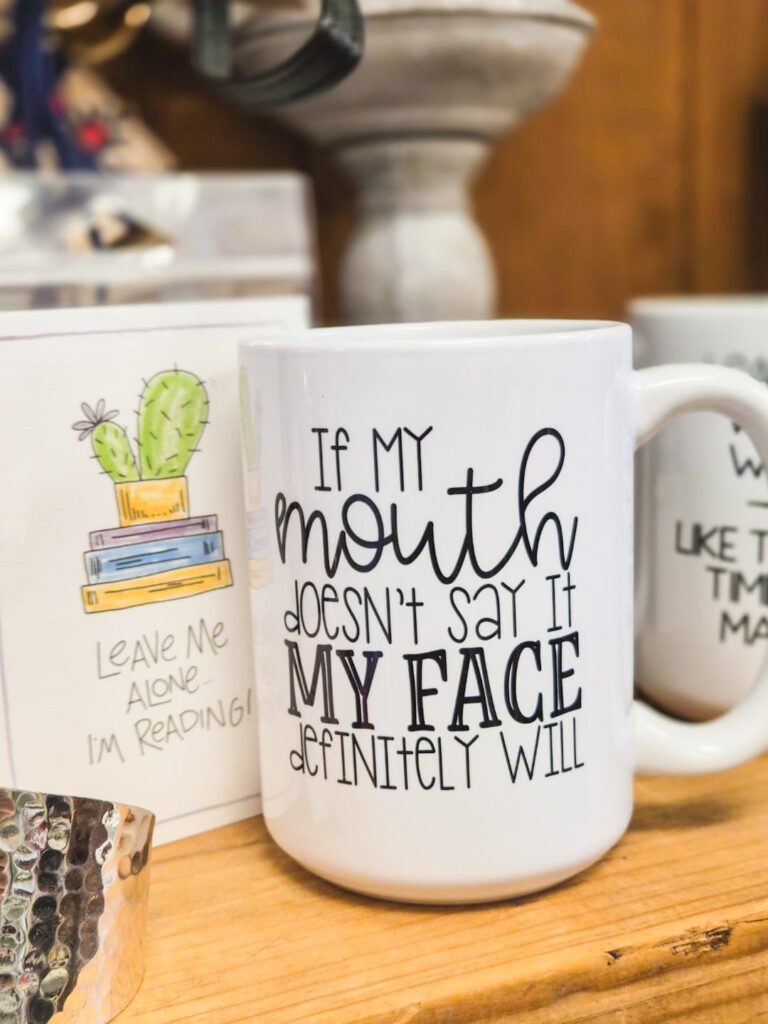 White ceramic mug with a funny quote about facial expressions on wooden surface