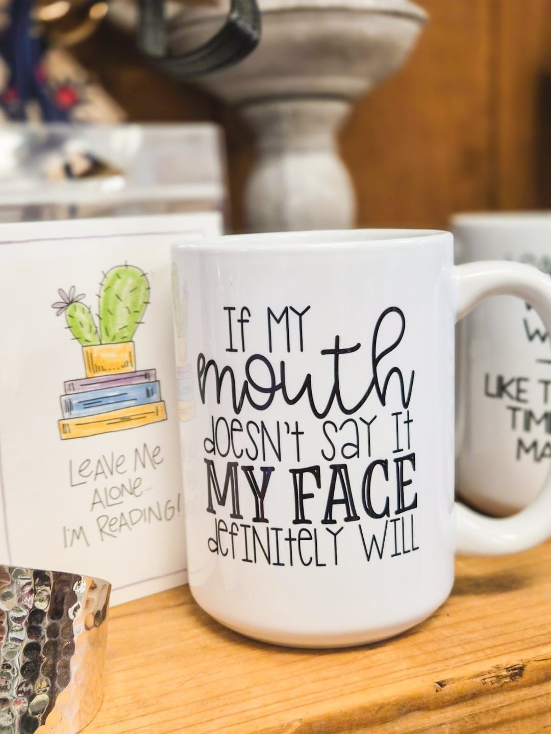 White ceramic mug with a funny quote about facial expressions on wooden surface