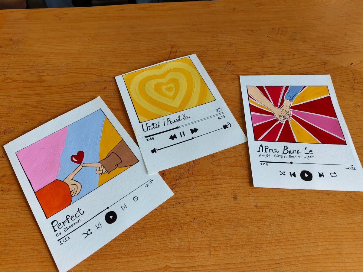 Three music-themed notecards with colorful art and digital music player interfaces on wood.