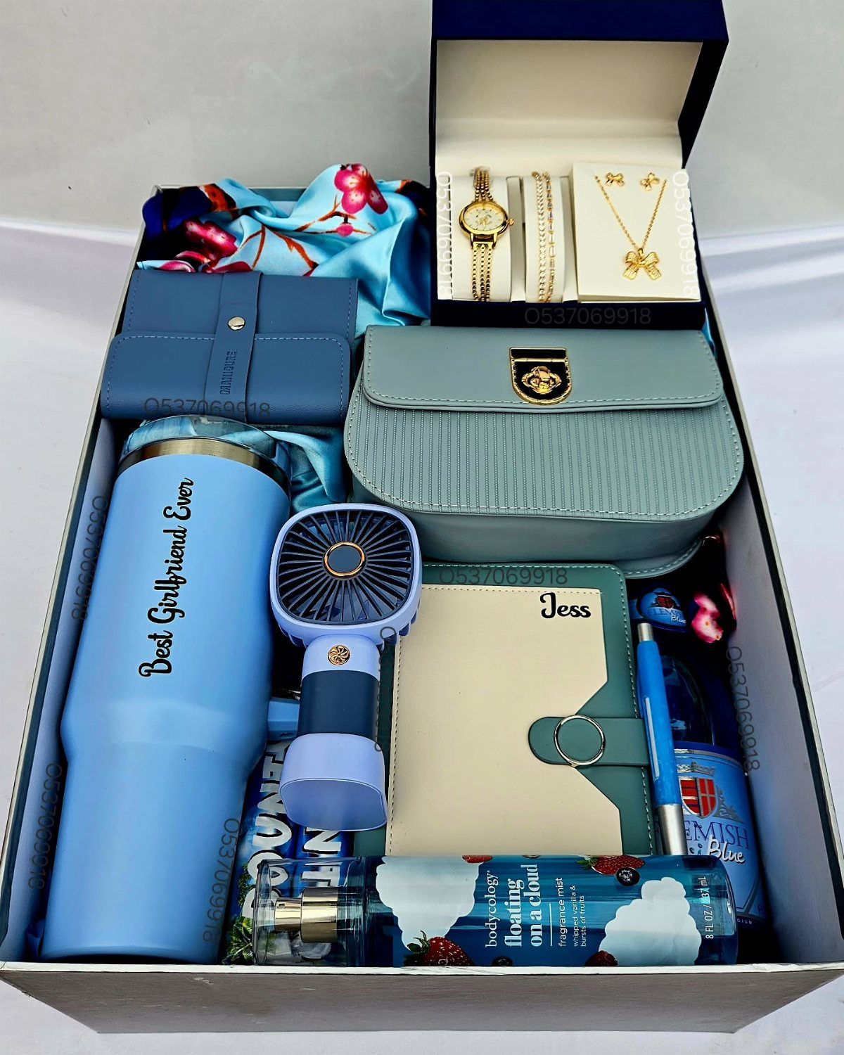 Blue themed gift box containing a tumbler, handbag, jewelry, and a notebook.