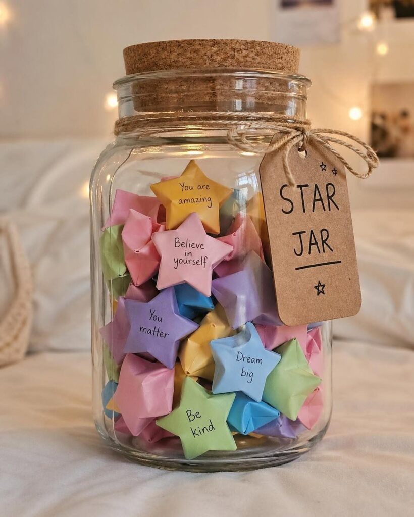Glass mason jar filled with colorful folded paper stars and a Star Jar tag.