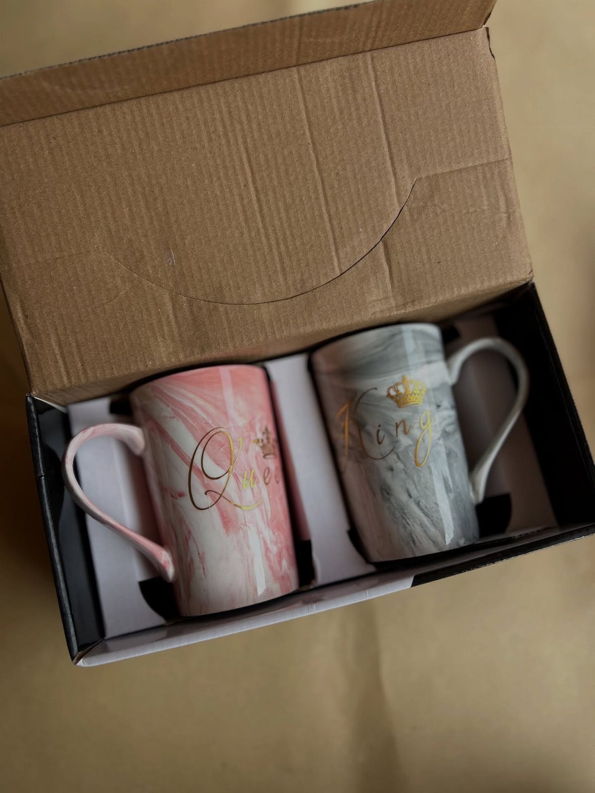 Two marble-patterned mugs labeled King and Queen in a black gift box