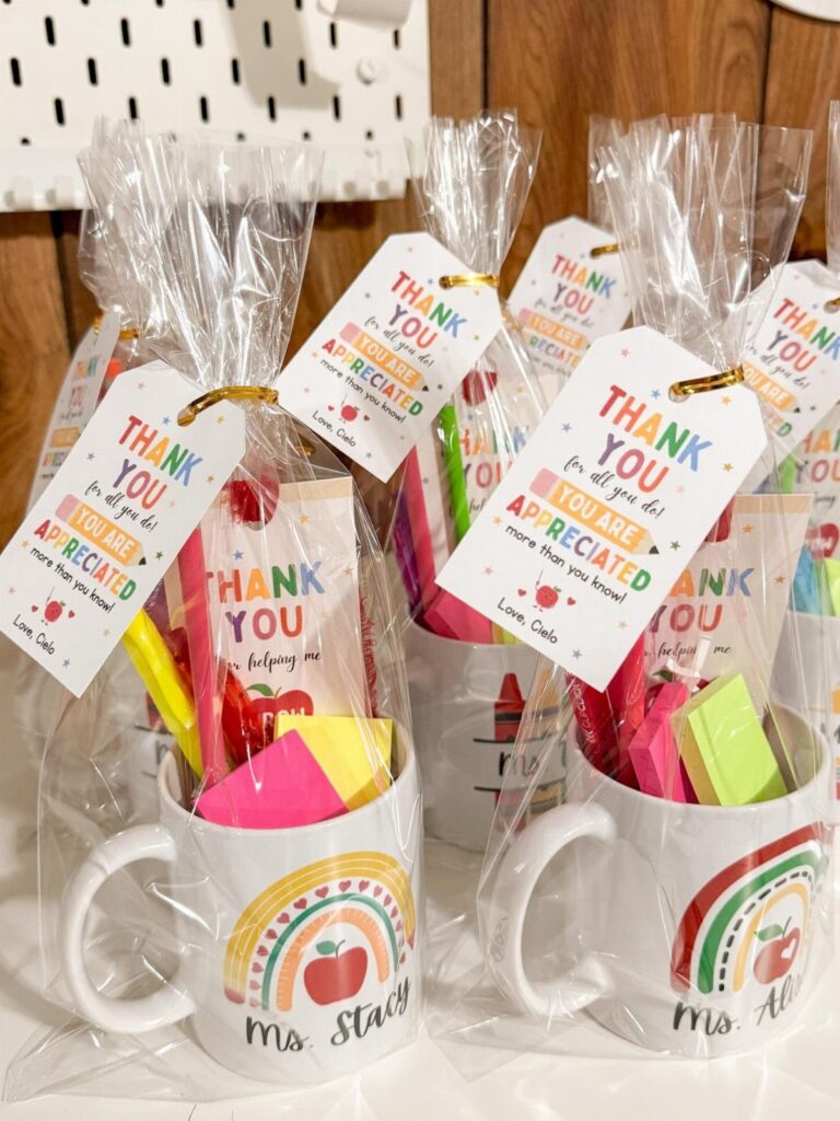 White mugs with rainbow designs filled with stationery and thank you tags.