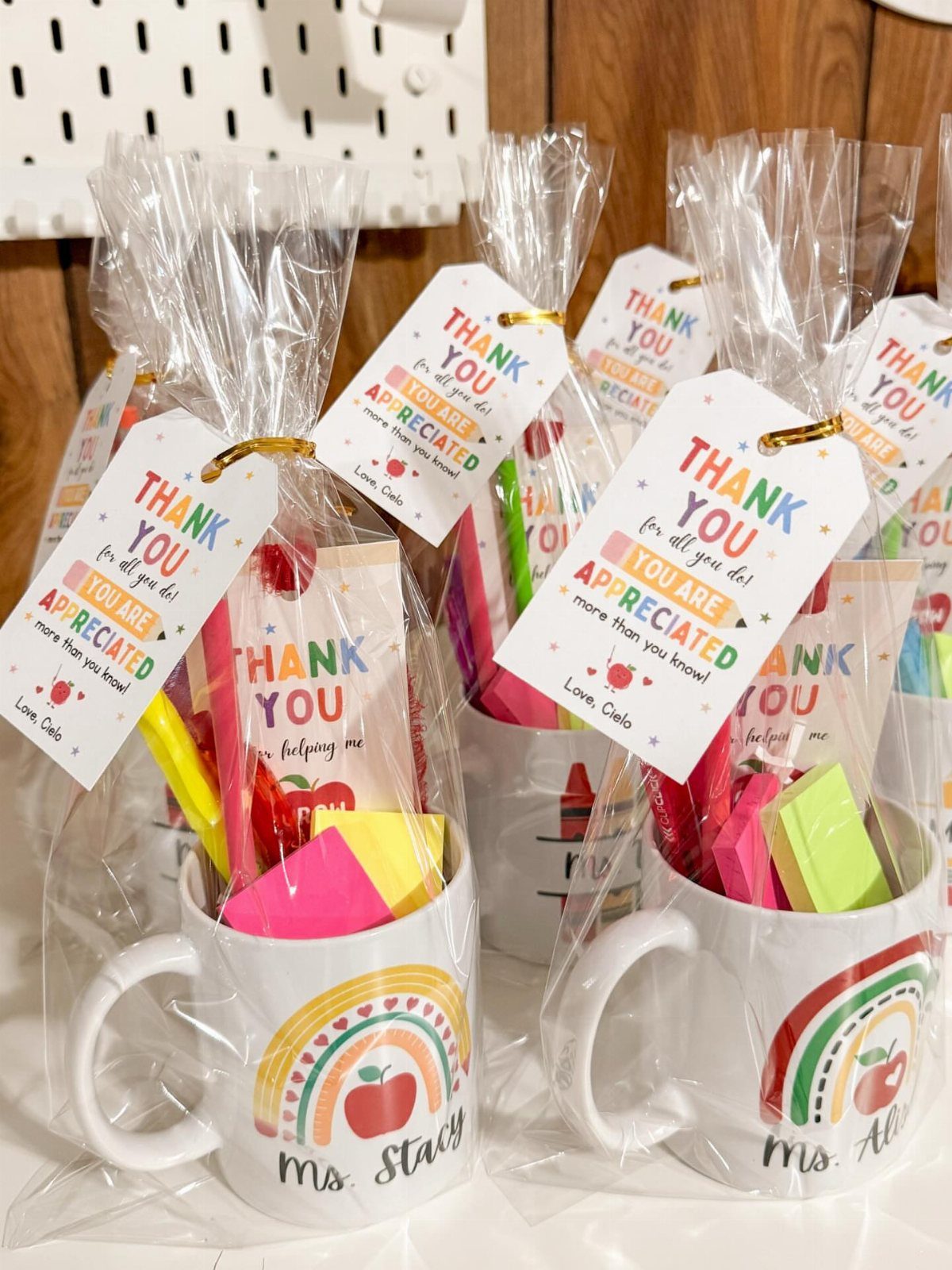 White mugs with rainbow designs filled with stationery and thank you tags.