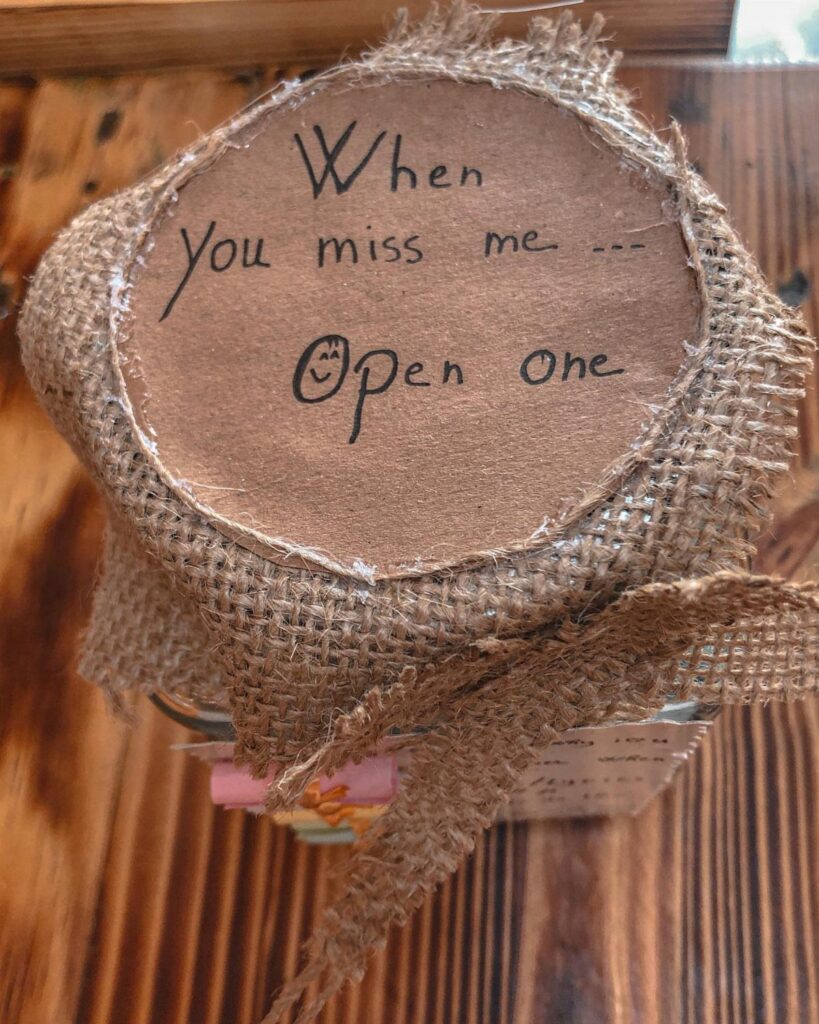 Memory jar with burlap wrap and handwritten note on a wooden table